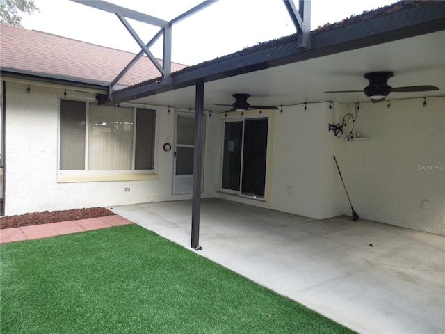 back of house featuring ceiling fan, a patio, and glass enclosure