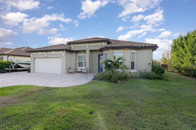 mediterranean / spanish home featuring a garage and a front lawn