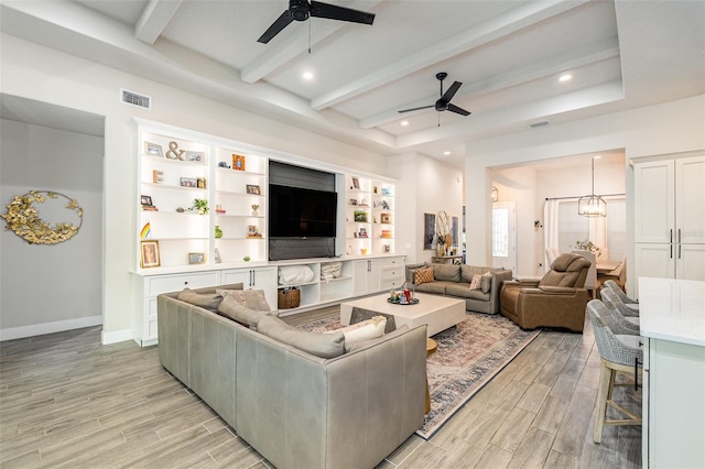 living room featuring light wood-type flooring, ceiling fan with notable chandelier, and beam ceiling