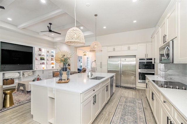 kitchen with white cabinets, sink, a center island with sink, and stainless steel appliances