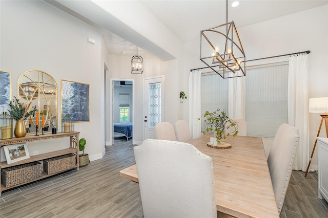 dining space with a towering ceiling and hardwood / wood-style floors