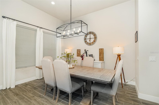 dining area featuring dark wood-type flooring and an inviting chandelier