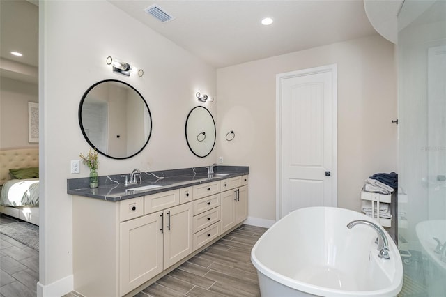 bathroom with hardwood / wood-style floors, a washtub, and vanity