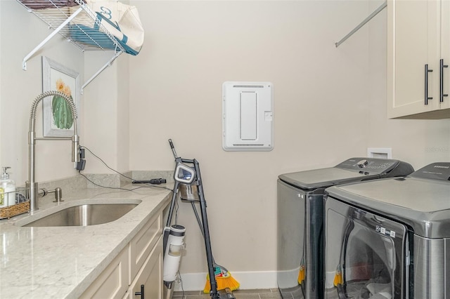 laundry room with tile patterned flooring, washing machine and dryer, cabinets, and sink