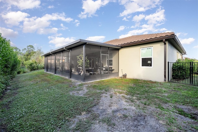 rear view of property with a sunroom and a yard