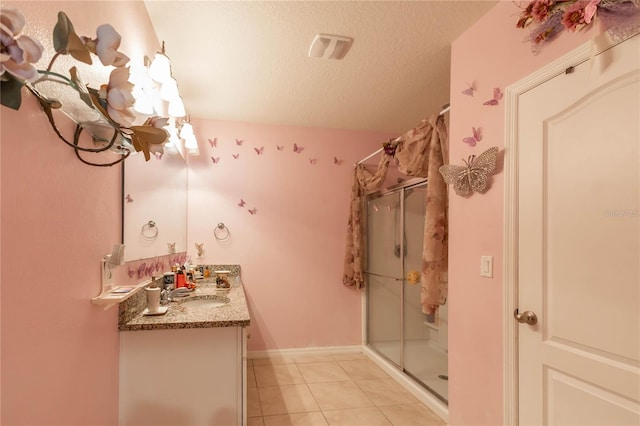 bathroom with vanity, a shower with shower curtain, a textured ceiling, and tile patterned floors