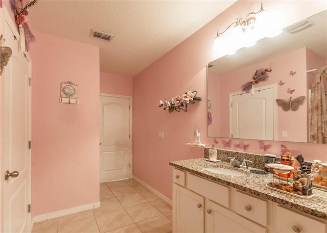 bathroom featuring vanity, a textured ceiling, and tile patterned flooring