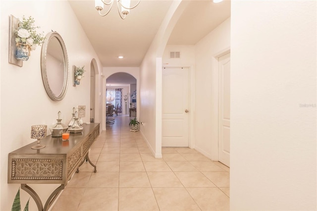 hall featuring an inviting chandelier and light tile patterned floors