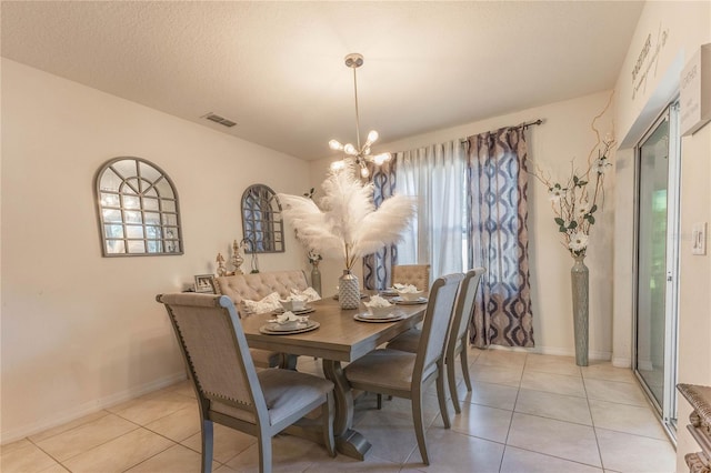 dining area with a chandelier, a textured ceiling, and light tile patterned floors