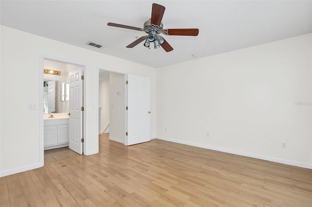 unfurnished bedroom featuring ensuite bathroom, light hardwood / wood-style flooring, and ceiling fan