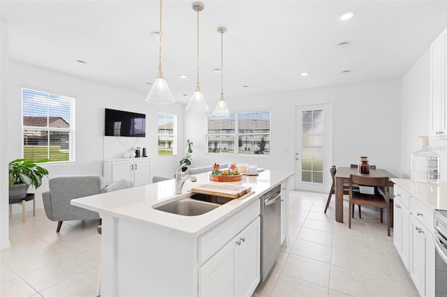 kitchen featuring hanging light fixtures, sink, a center island with sink, white cabinetry, and dishwasher