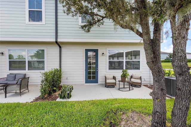 rear view of house featuring a lawn, cooling unit, and a patio area