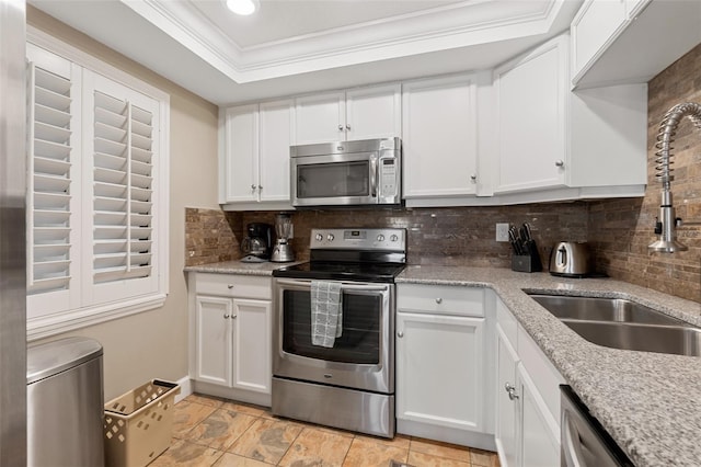 kitchen with stainless steel appliances, white cabinetry, and tasteful backsplash