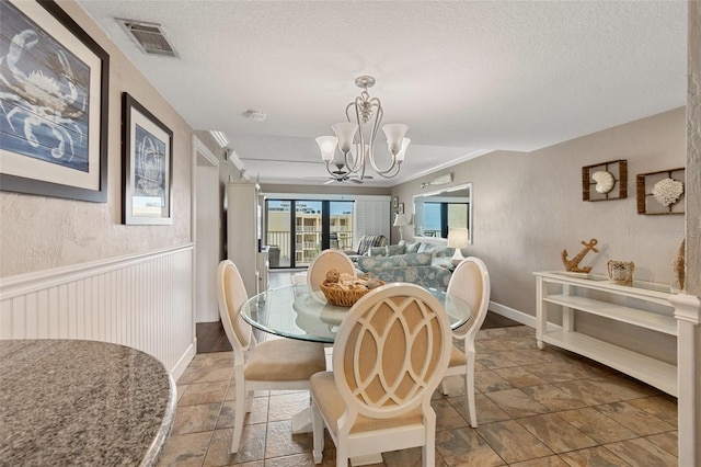 dining area with a chandelier and a textured ceiling