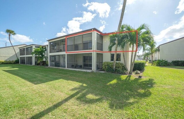 back of house featuring a yard and a sunroom