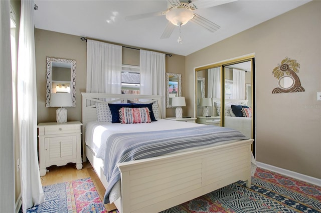 bedroom with light hardwood / wood-style floors, a closet, and ceiling fan