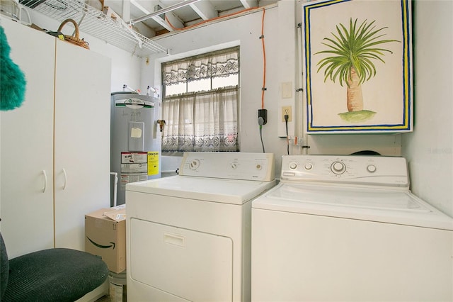 laundry area featuring cabinets, electric water heater, and washing machine and clothes dryer