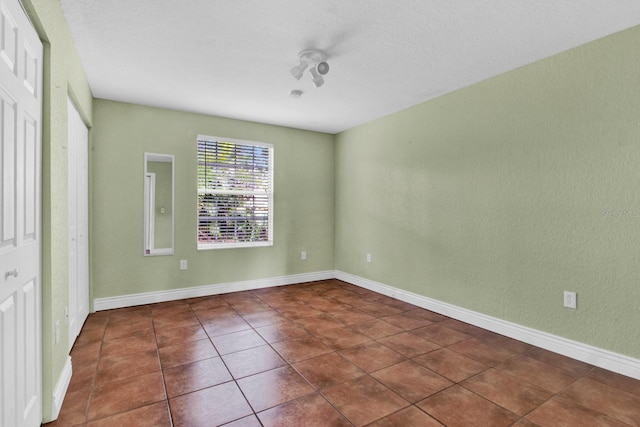 unfurnished bedroom featuring dark tile patterned floors