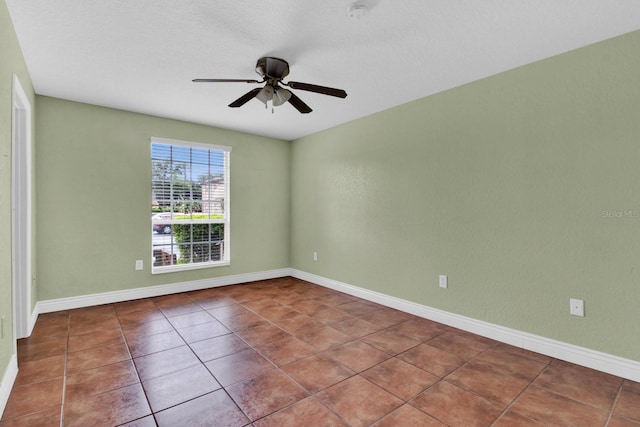 tiled empty room featuring ceiling fan