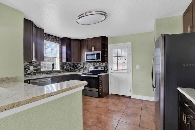 kitchen featuring appliances with stainless steel finishes, kitchen peninsula, sink, and a wealth of natural light