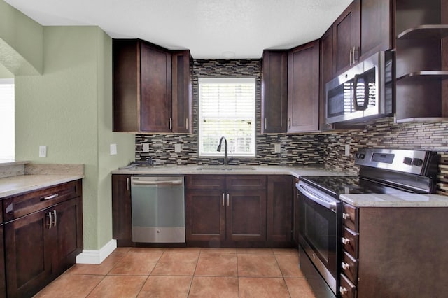 kitchen with dark brown cabinetry, backsplash, appliances with stainless steel finishes, and sink