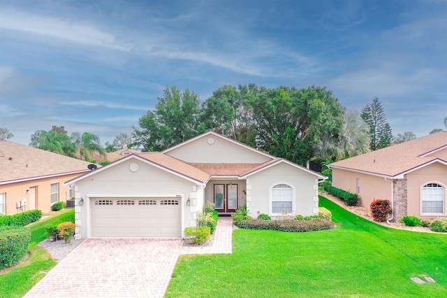 ranch-style home with a garage and a front lawn