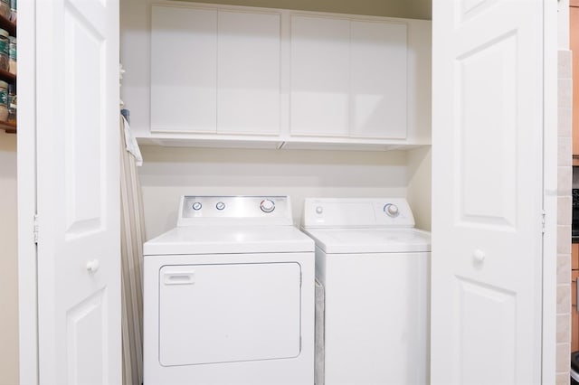 laundry room with cabinets and washer and dryer