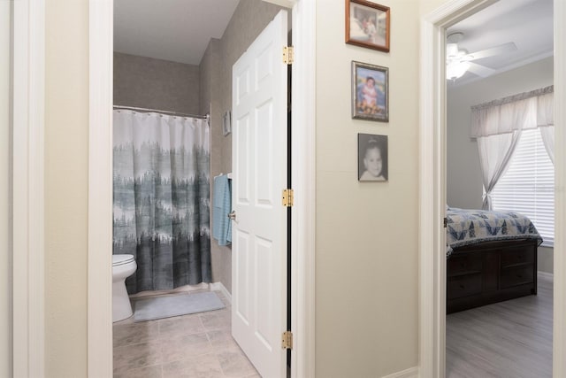 bathroom featuring ceiling fan, a shower with curtain, hardwood / wood-style flooring, and toilet