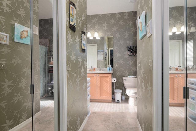 bathroom with a shower, tile patterned flooring, vanity, and toilet