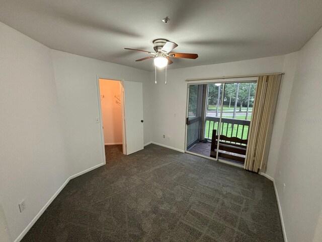 empty room featuring dark colored carpet and ceiling fan