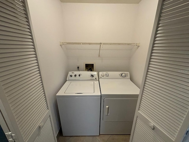 laundry area featuring light tile patterned floors and washer and dryer