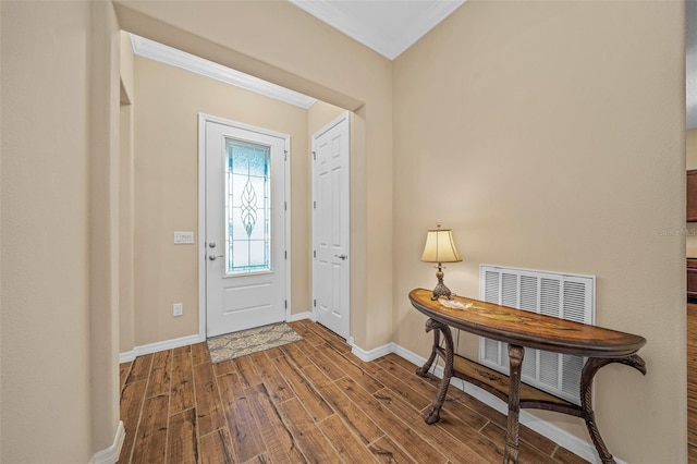 foyer entrance featuring ornamental molding and hardwood / wood-style floors