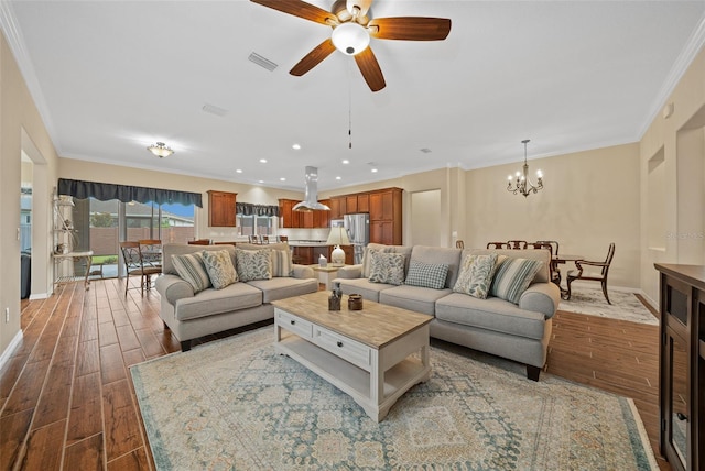 living room with crown molding, ceiling fan with notable chandelier, and hardwood / wood-style floors