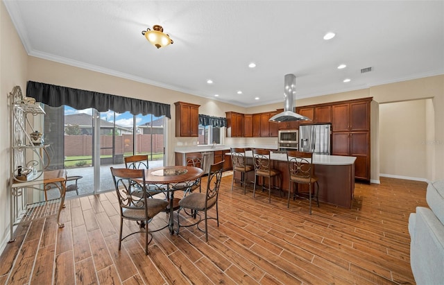 dining space with light hardwood / wood-style floors, sink, and crown molding