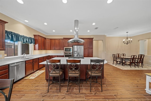 kitchen with light hardwood / wood-style flooring, stainless steel appliances, an inviting chandelier, and a kitchen island