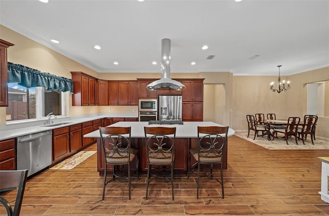 kitchen featuring stainless steel appliances, hanging light fixtures, light hardwood / wood-style floors, and a center island