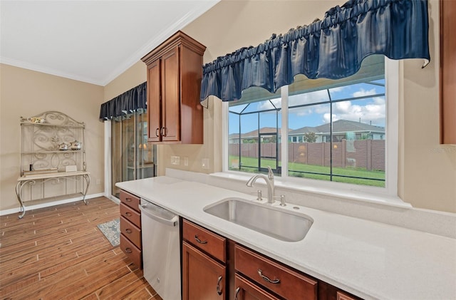 kitchen featuring crown molding, light wood-type flooring, sink, and stainless steel dishwasher