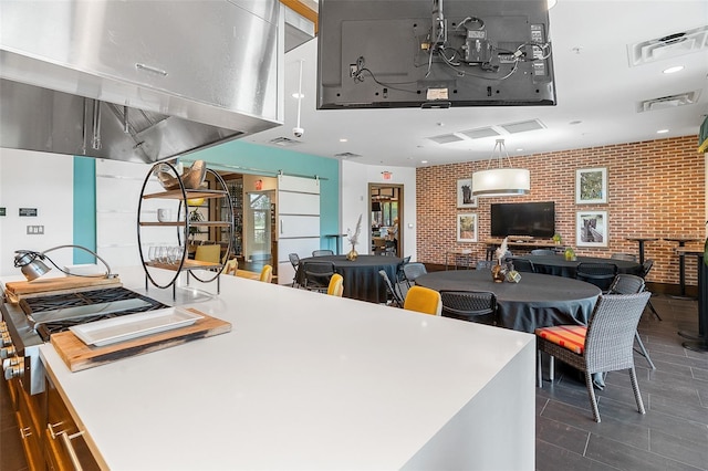 kitchen featuring a barn door and brick wall