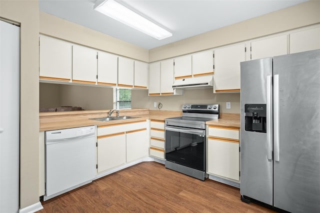 kitchen with appliances with stainless steel finishes, light hardwood / wood-style floors, sink, and white cabinets