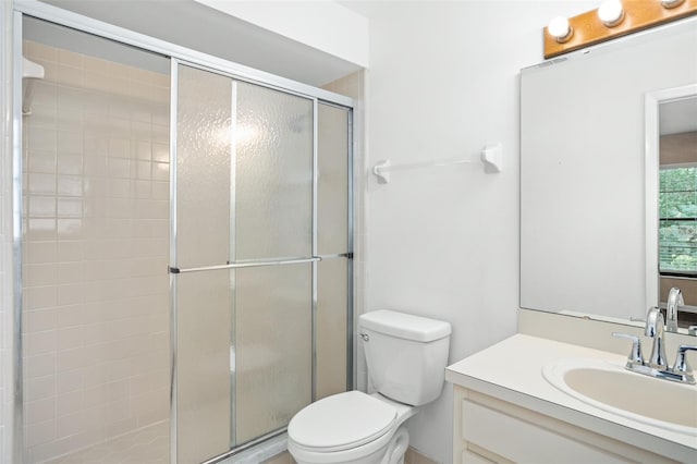 bathroom featuring vanity, toilet, and an enclosed shower