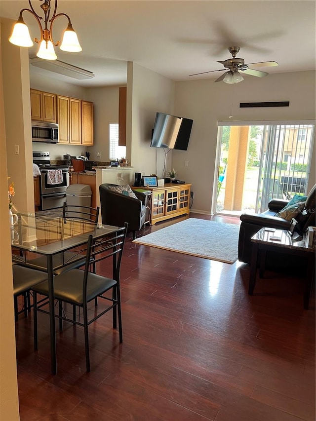 dining room featuring ceiling fan with notable chandelier and dark hardwood / wood-style flooring