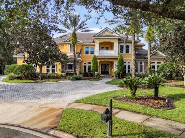 view of front facade with a balcony and a front lawn