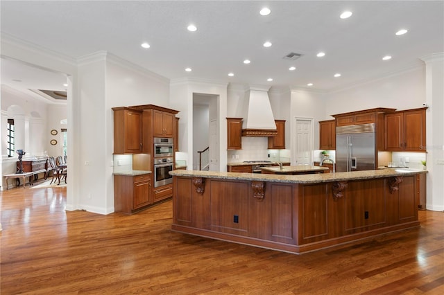 kitchen with a large island, a breakfast bar, appliances with stainless steel finishes, and dark wood-type flooring