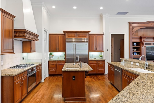 kitchen featuring appliances with stainless steel finishes, sink, an island with sink, and dark hardwood / wood-style flooring