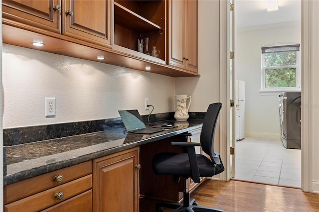 office area with built in desk, ornamental molding, washer / dryer, and light hardwood / wood-style flooring