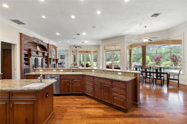 kitchen featuring plenty of natural light, a kitchen island with sink, and sink