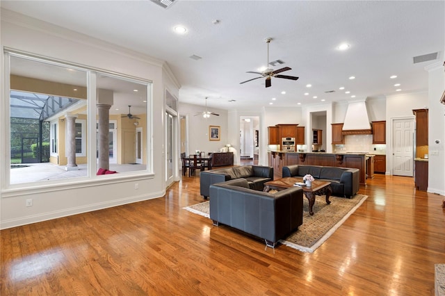 living room with ornamental molding, hardwood / wood-style flooring, and ornate columns