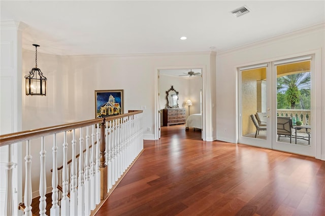 hallway with a chandelier, hardwood / wood-style flooring, and crown molding