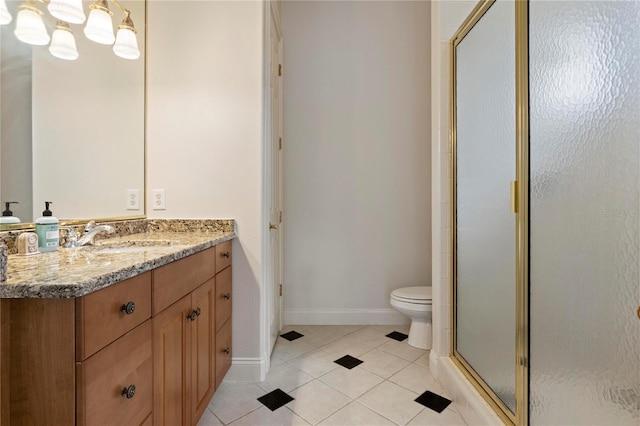 bathroom with tile patterned floors, a shower with shower door, vanity, and toilet