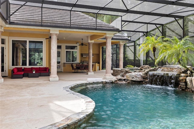 view of pool featuring glass enclosure, outdoor lounge area, ceiling fan, a patio area, and pool water feature